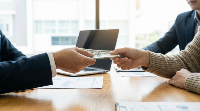 A person receiving cash quickly, symbolizing the speed of an emergency loan.